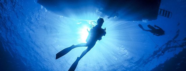 cayman brac divers under boat 1060x403 Min